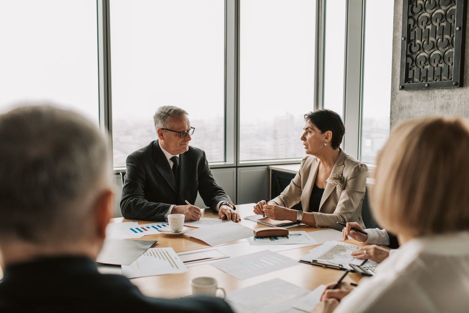 Gestão de Crise Online — Business professionals engaged in a strategic meeting in a modern office setting with natural light.