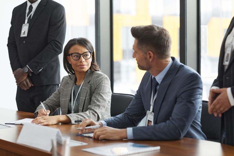 Gestão de Crise Online — Diverse business professionals discussing strategy during a modern board meeting.