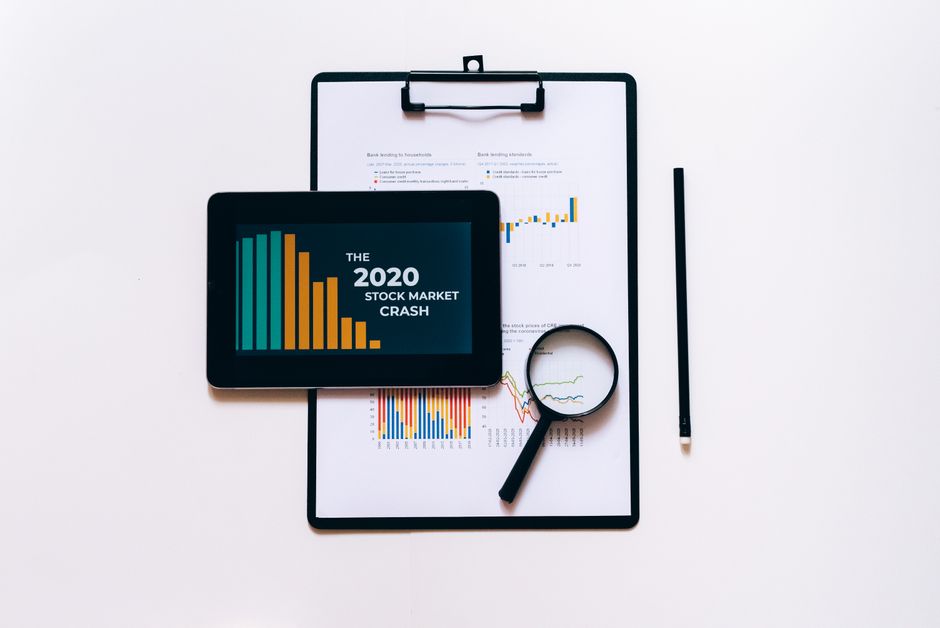 Gestão de Crise Online — Tablet, magnifying glass, and clipboard for stock market analysis.